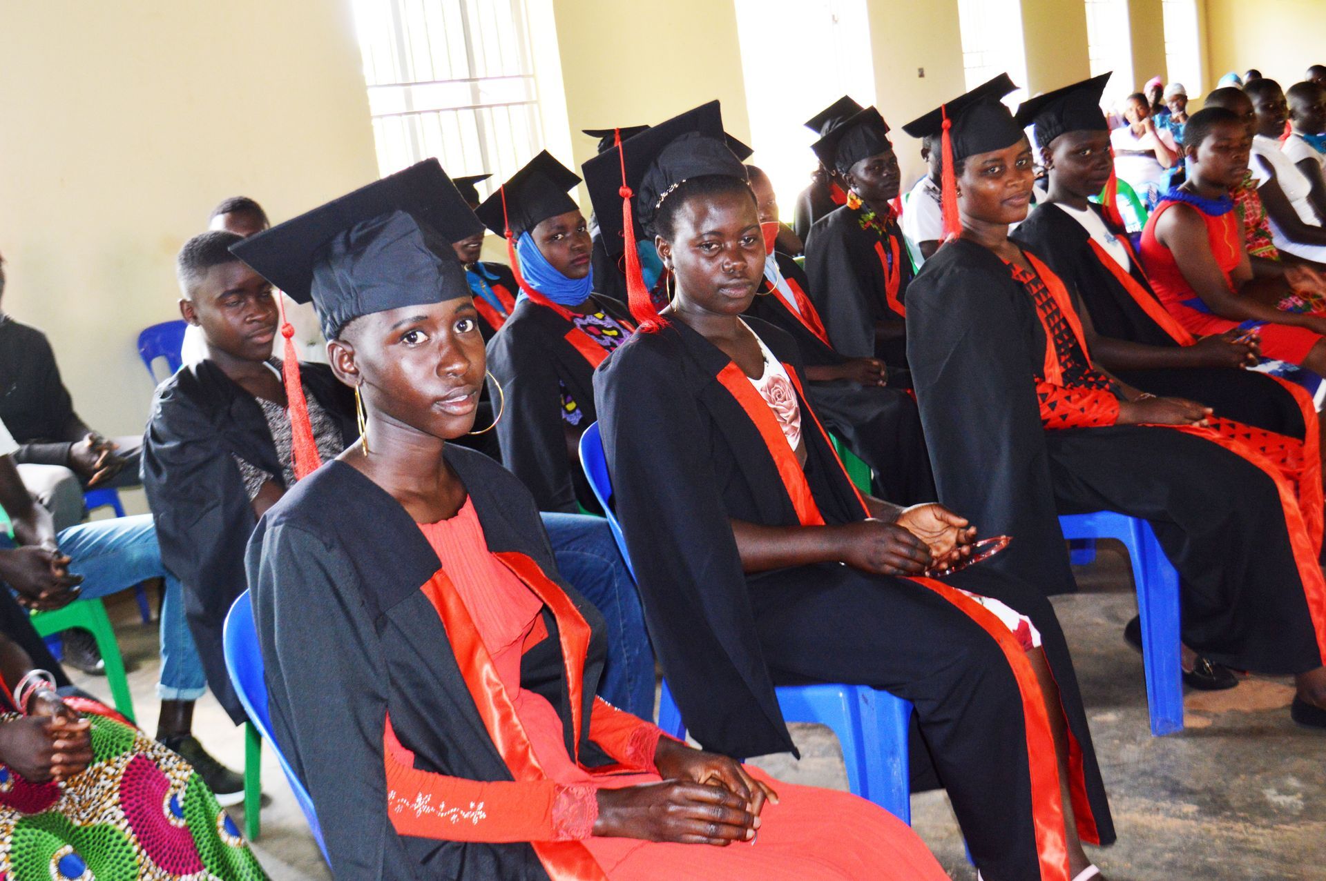 Group of smiling children with dots on their foreheads, waving.