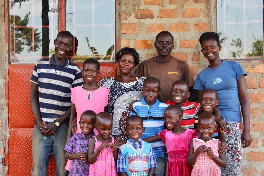 A group of people are posing for a picture in front of a brick building.