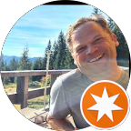 Ein lächelnder Mann sitzt in einem Kreis mit einem Sternsymbol.