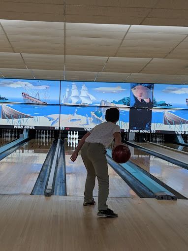 A man is throwing a bowling ball in a bowling alley