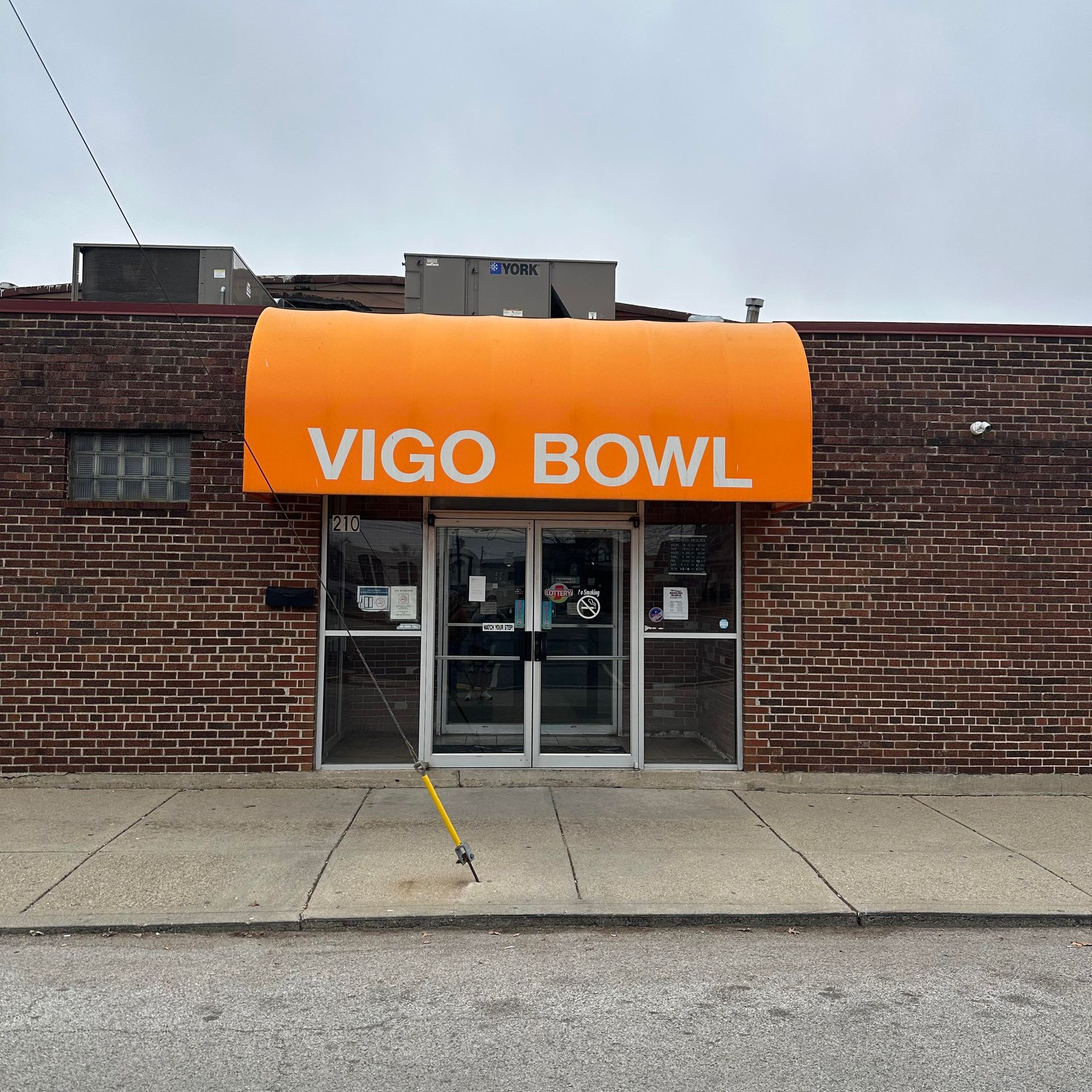 A brick building with an orange awning that says vigo bowl