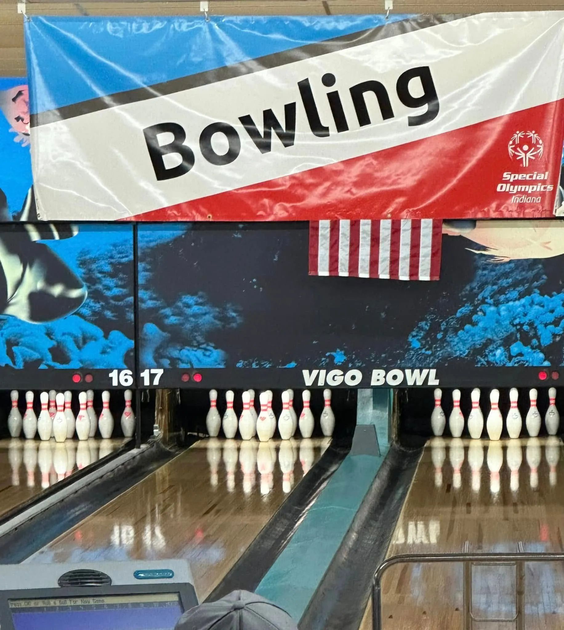 Bowling lane with pins set up; banner says 