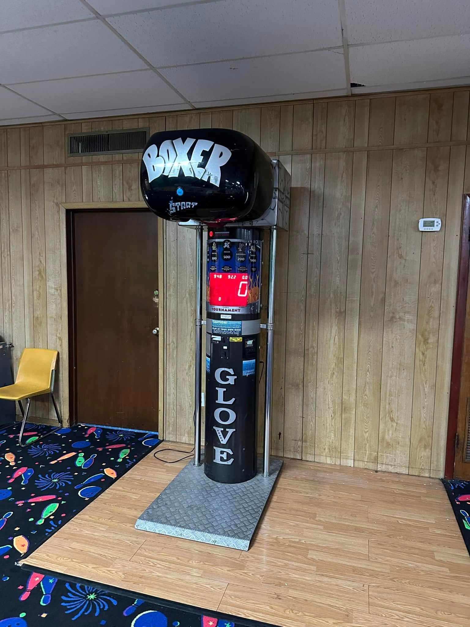 A boxing machine is sitting in a room next to a door.