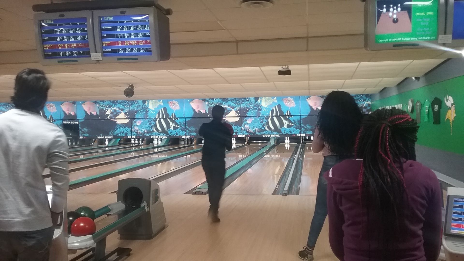 A group of people are playing bowling in a bowling alley.
