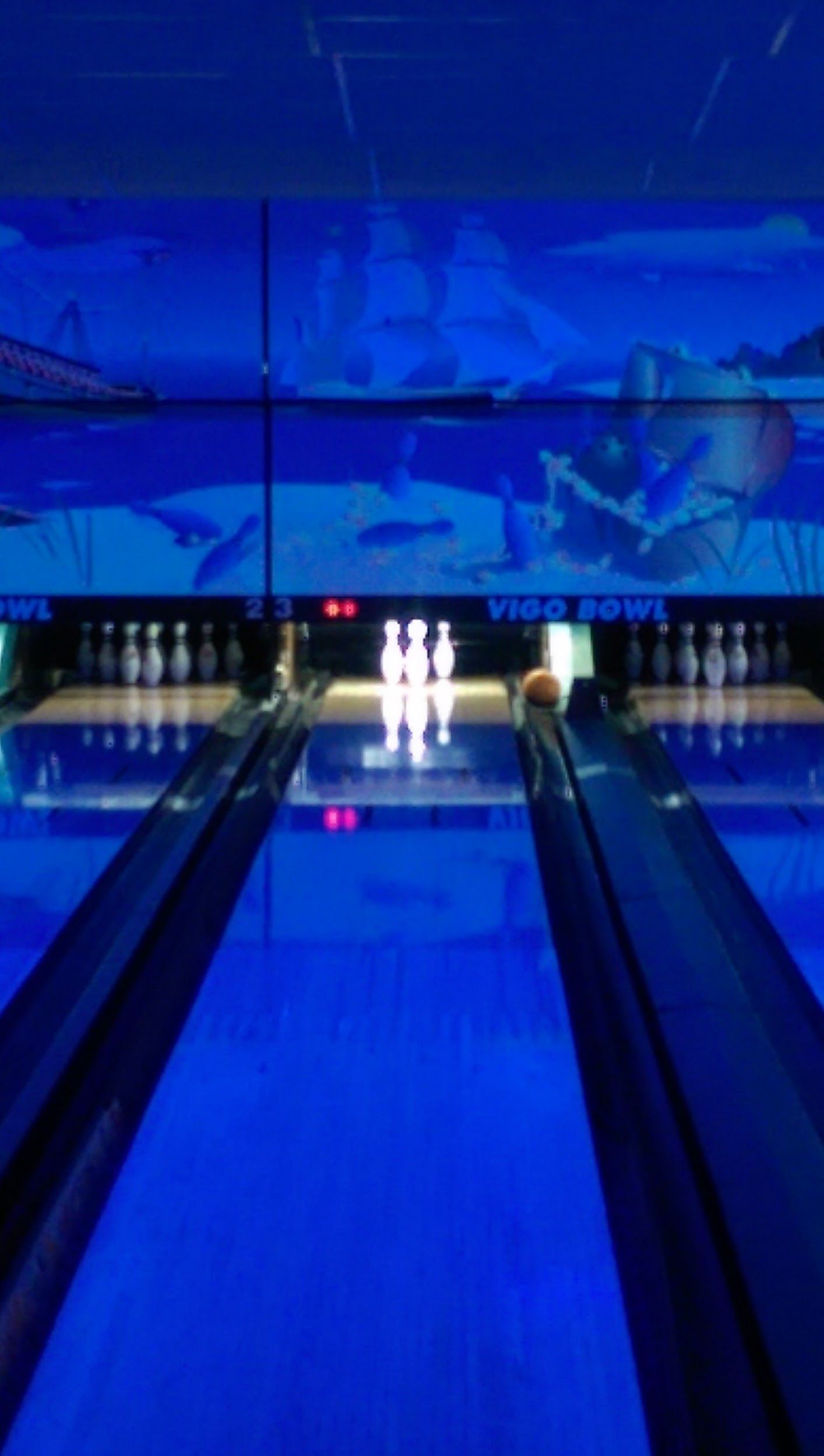 A bowling alley is lit up with blue lights