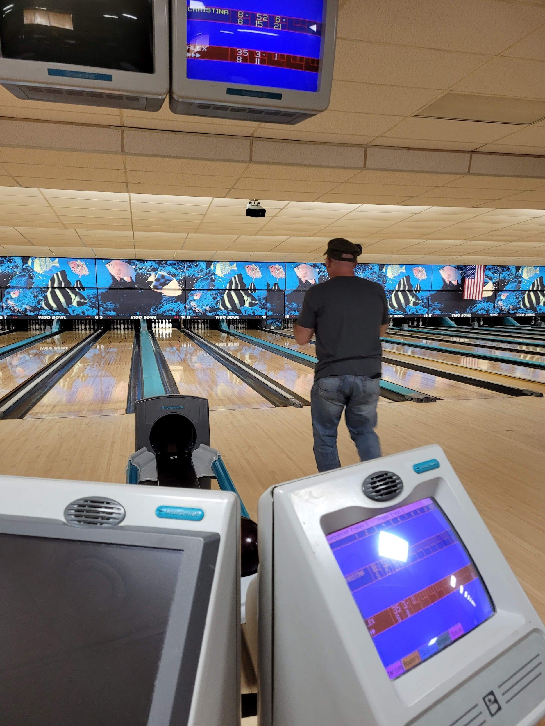 A man is playing bowling in a bowling alley