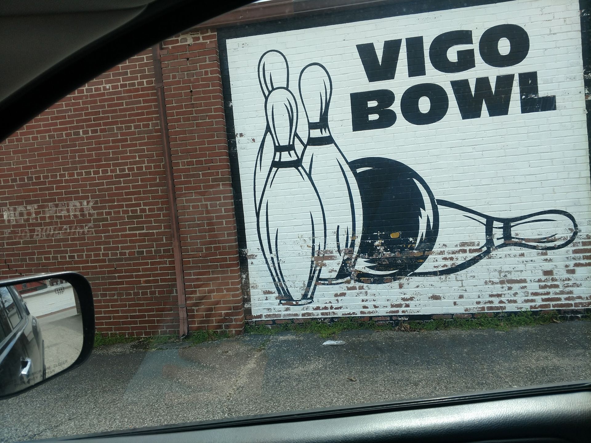 A sign for vigo bowl is painted on a brick wall