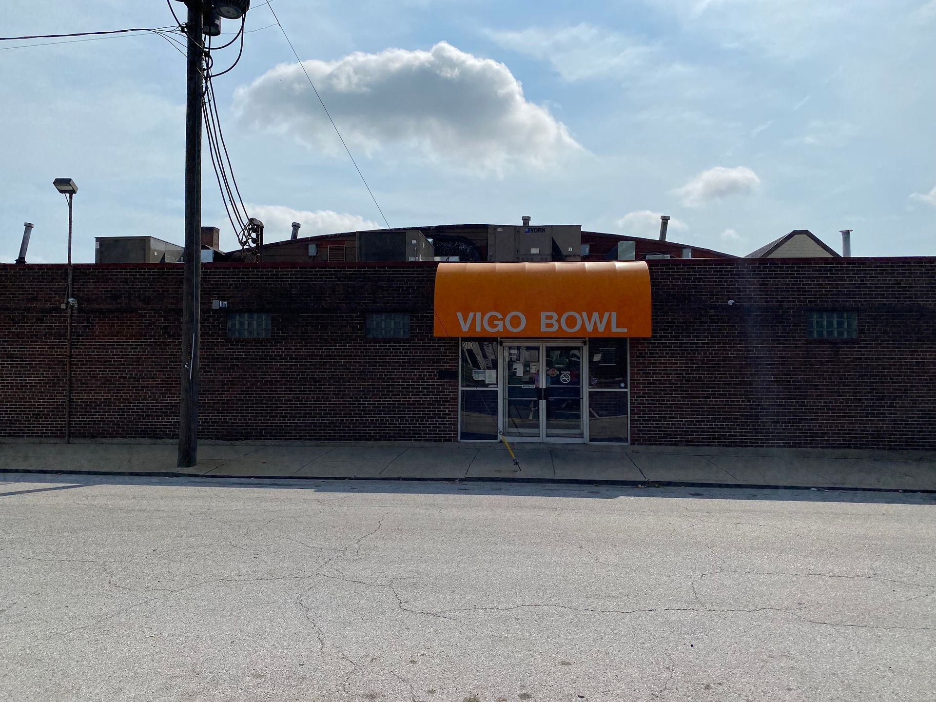 A brick building with an orange awning that says vigo bowl