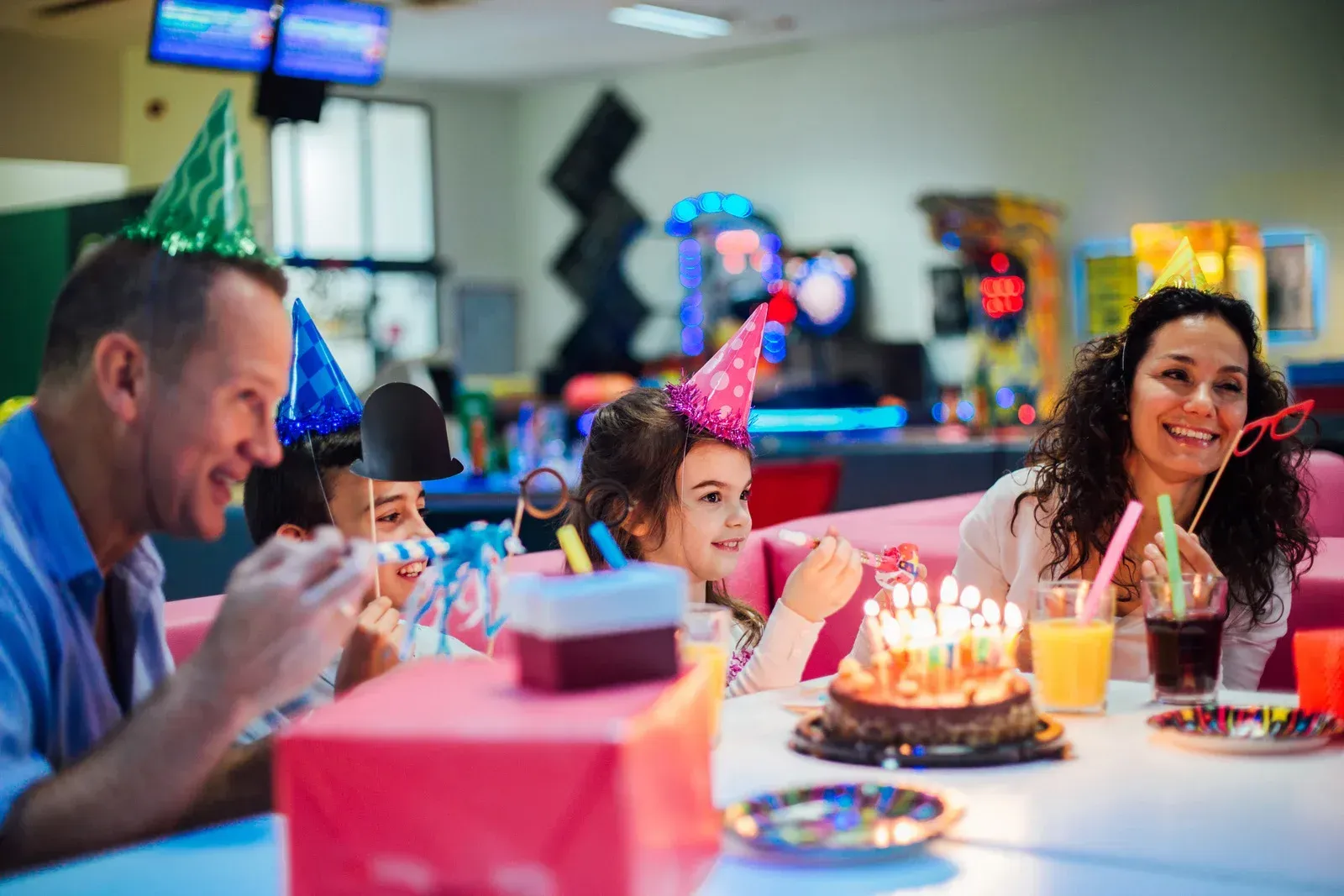 A family is having a birthday party at a bowling alley.