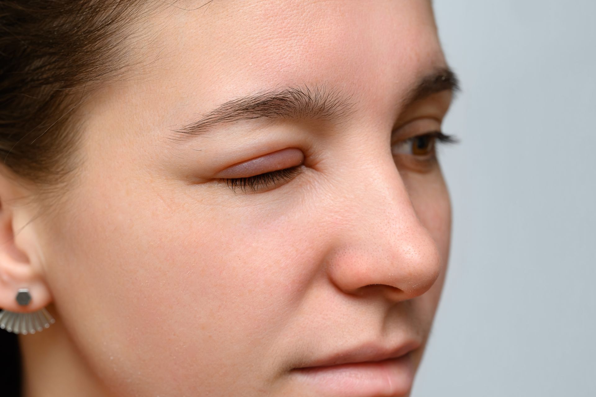 A close up of a woman 's face with her eyes closed.