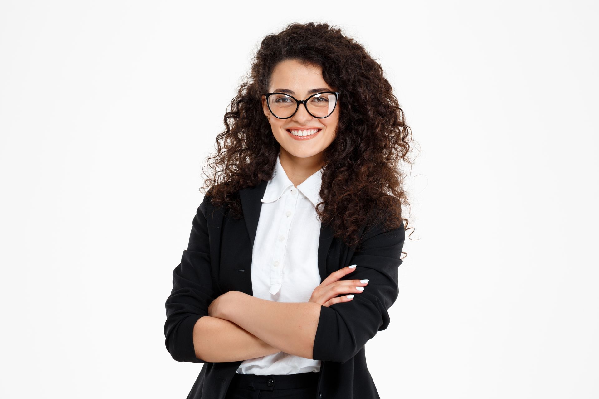 A woman wearing glasses and a black jacket is standing with her arms crossed.