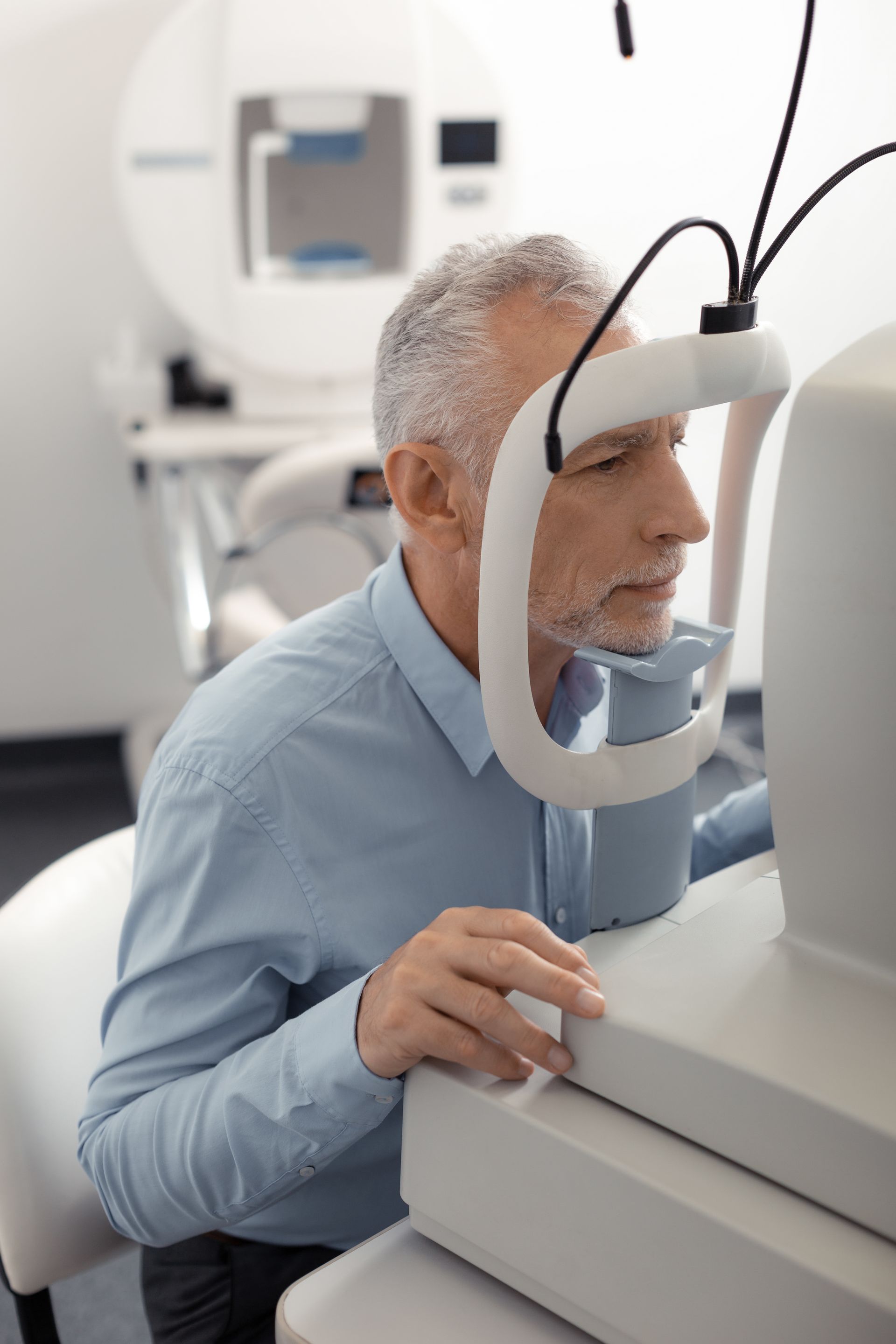 A man is getting his eyes checked by an ophthalmologist.