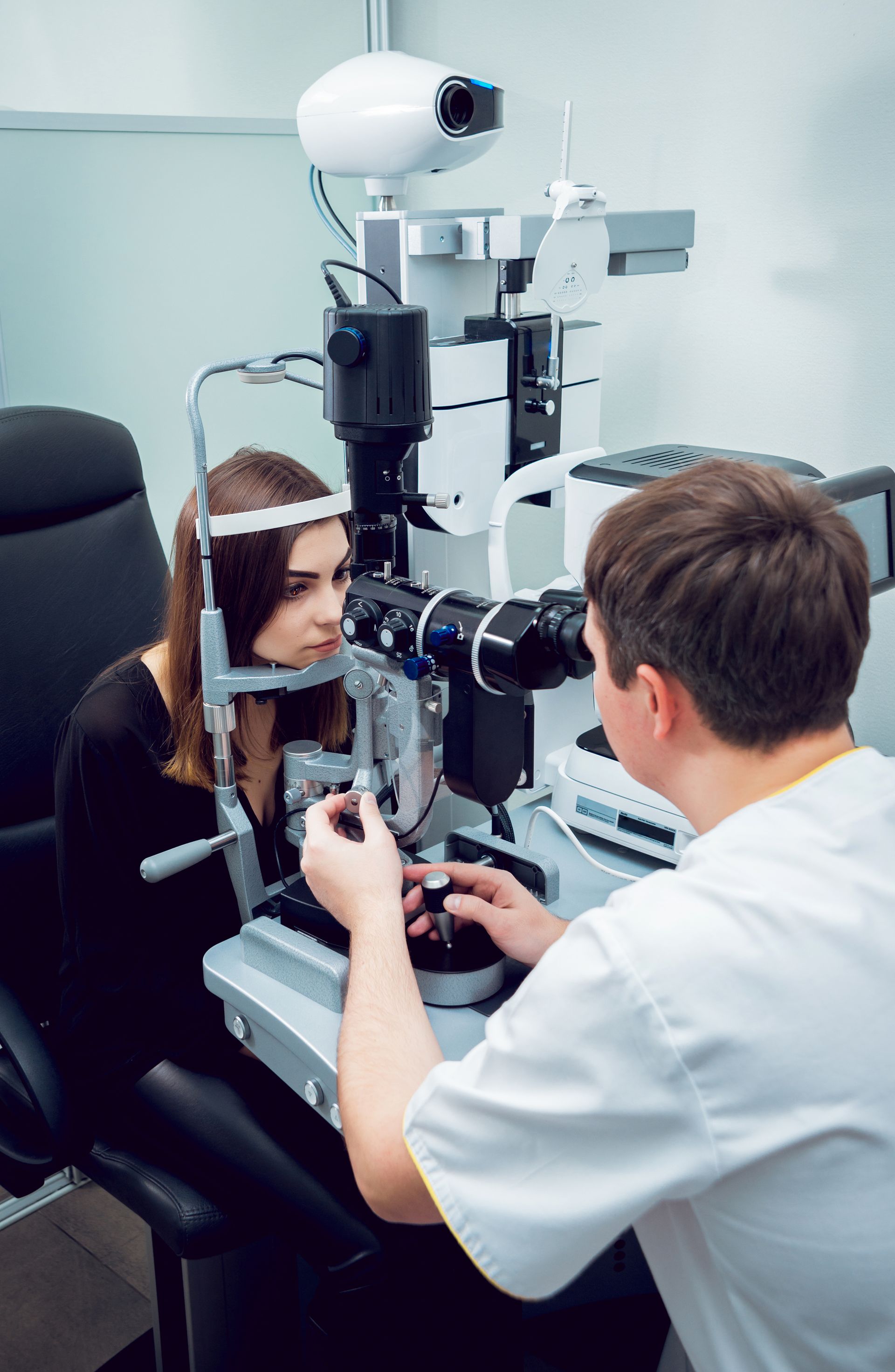 A woman is getting her eyes examined by an ophthalmologist.