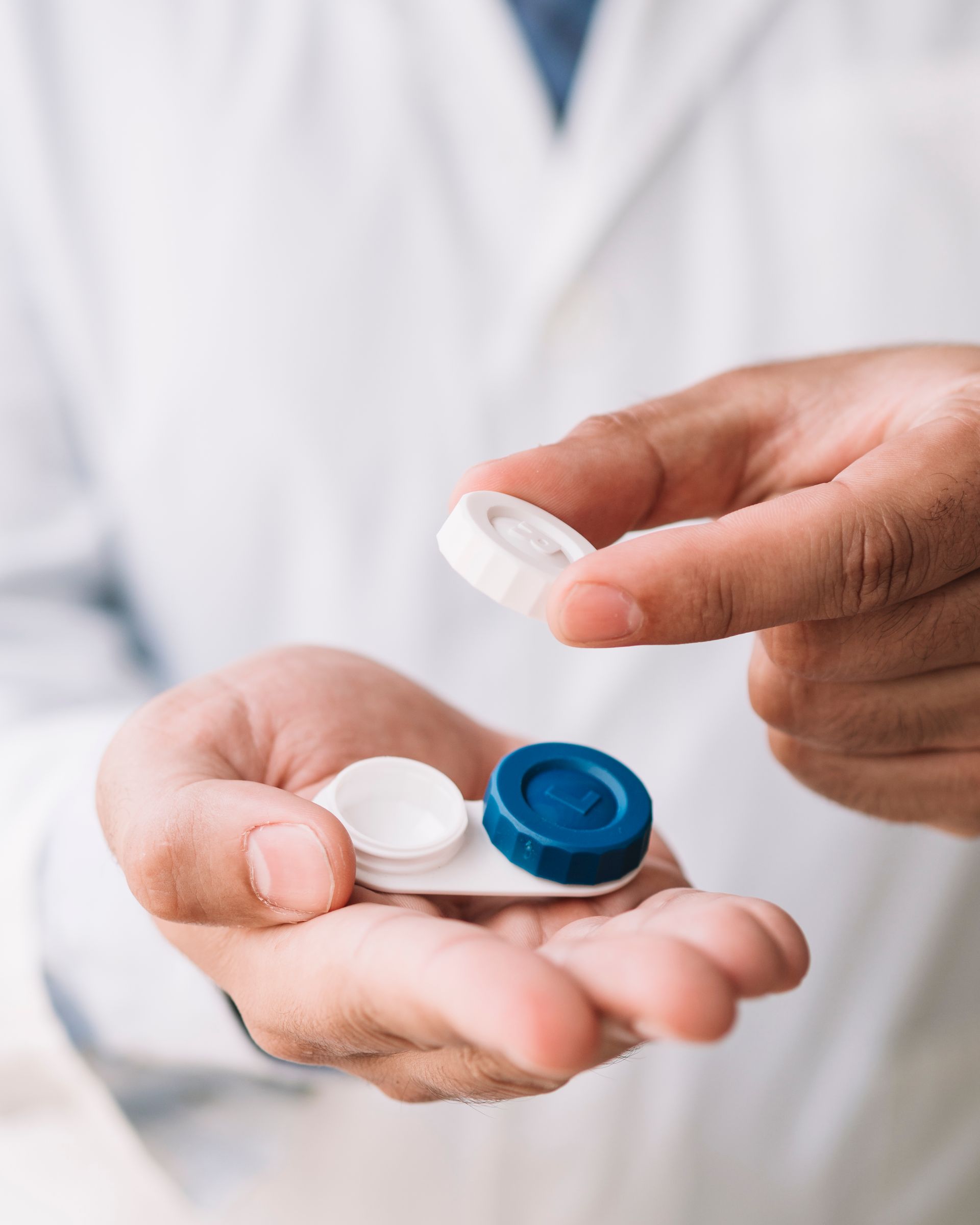 A person is holding a contact lens case in their hand