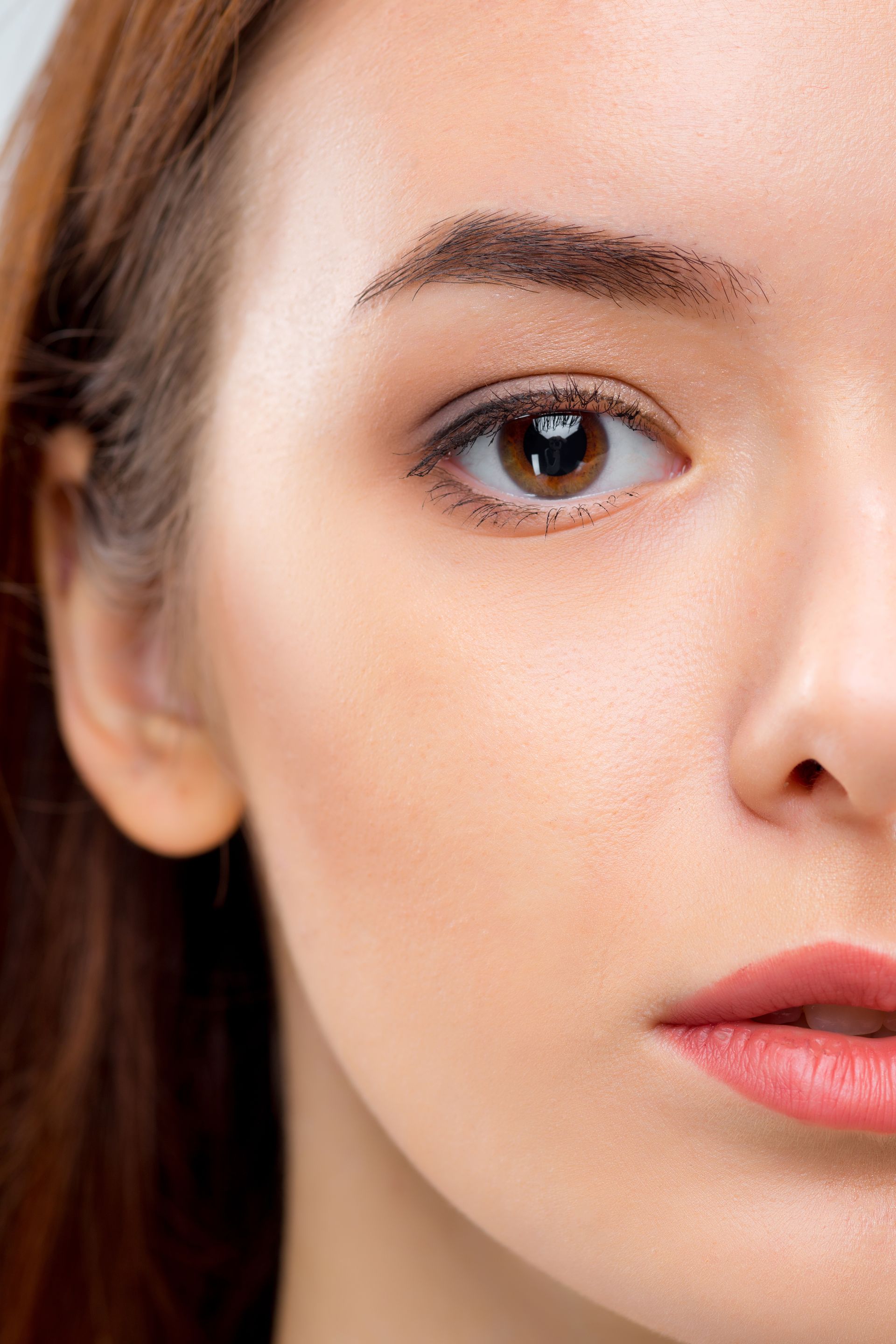 A close up of a woman 's face with brown eyes and red lips.