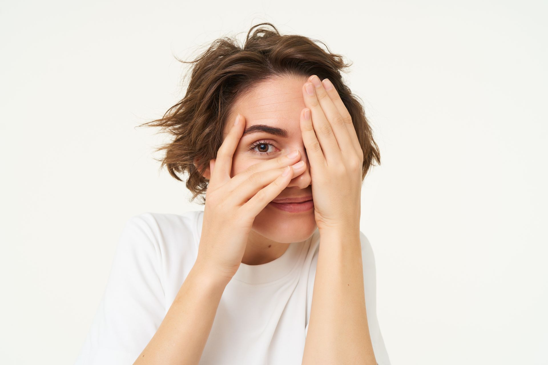 A woman is covering her eyes with her hands.