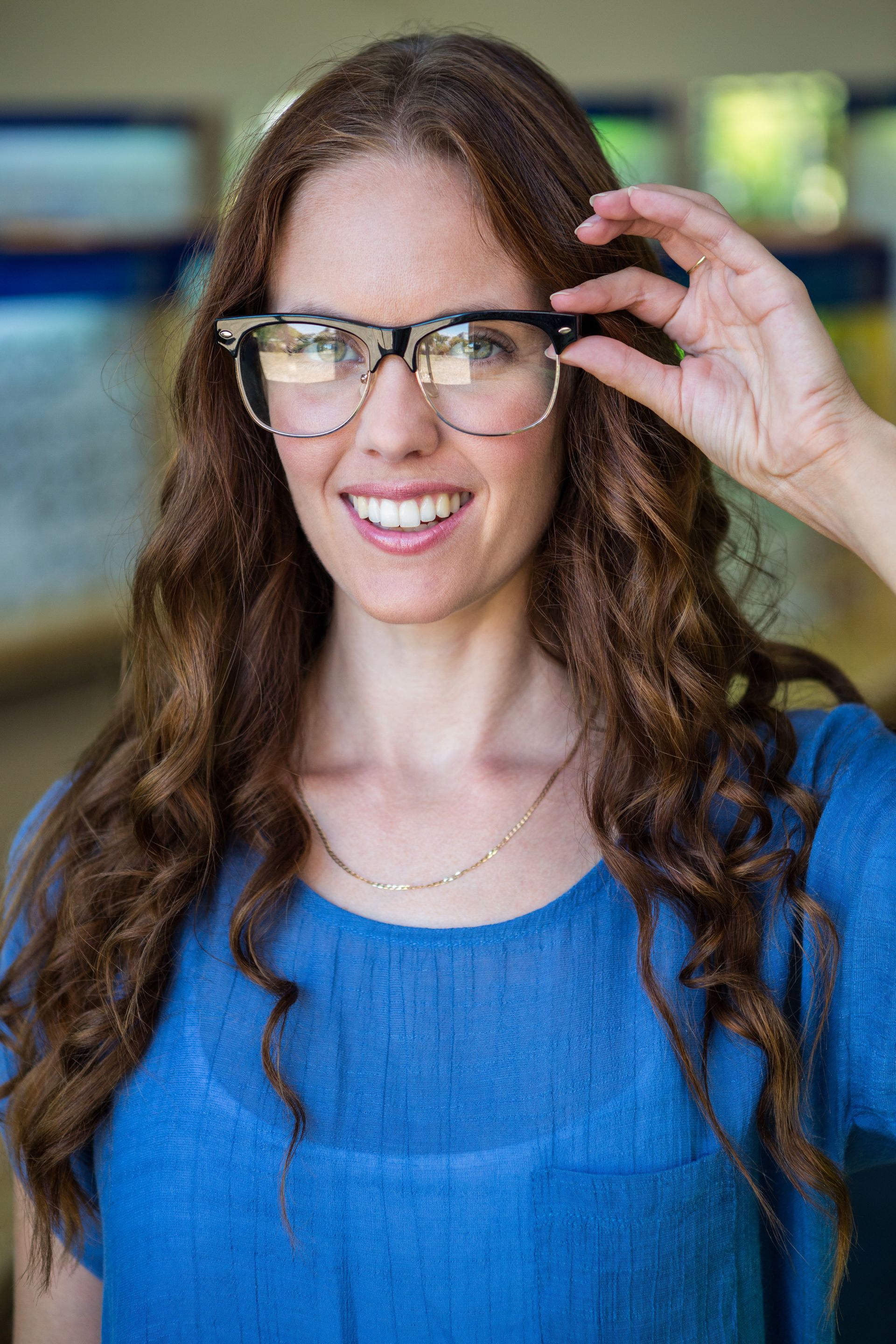 A woman is trying on glasses in an optical shop.