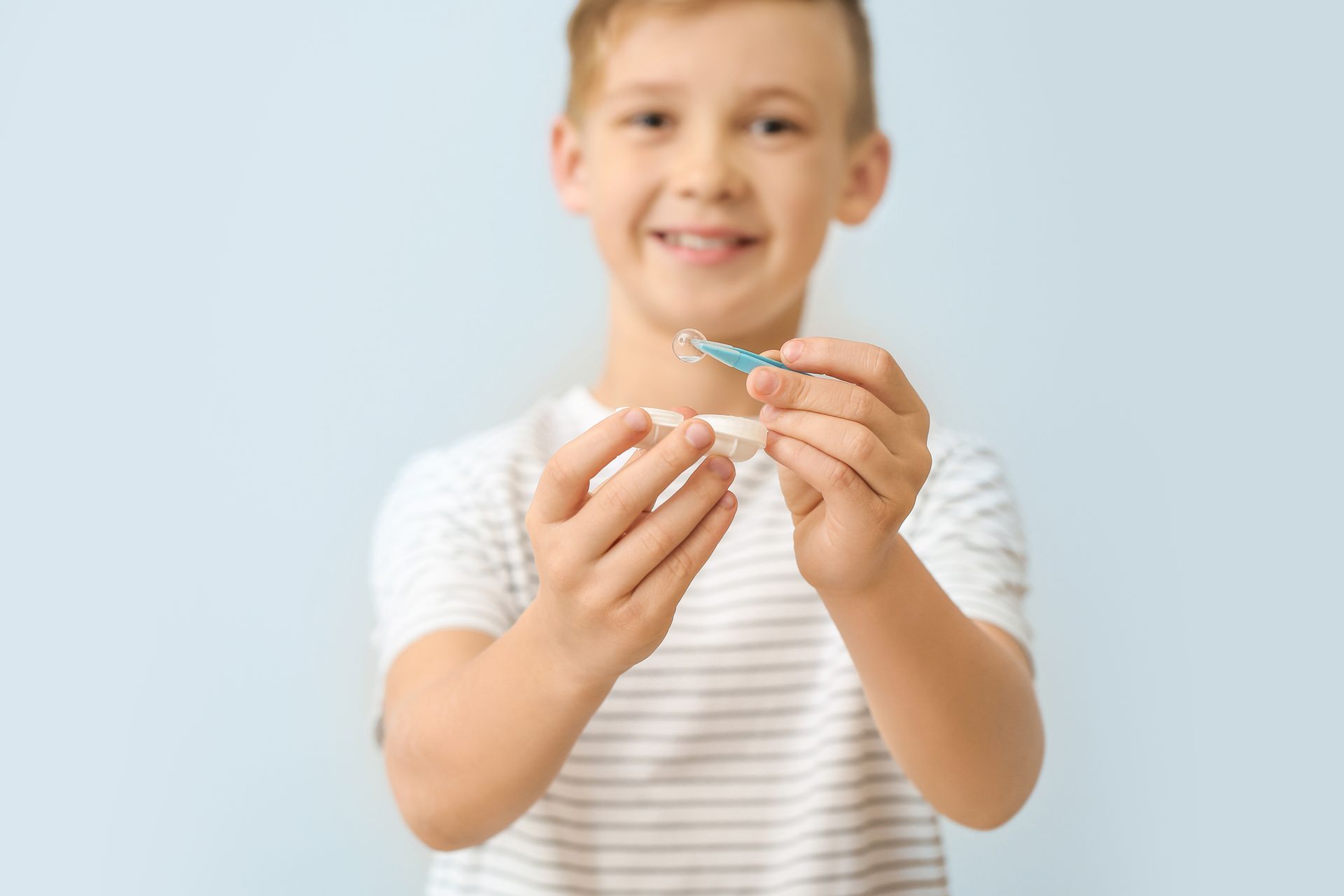 A young boy is holding a toothbrush in his hands.