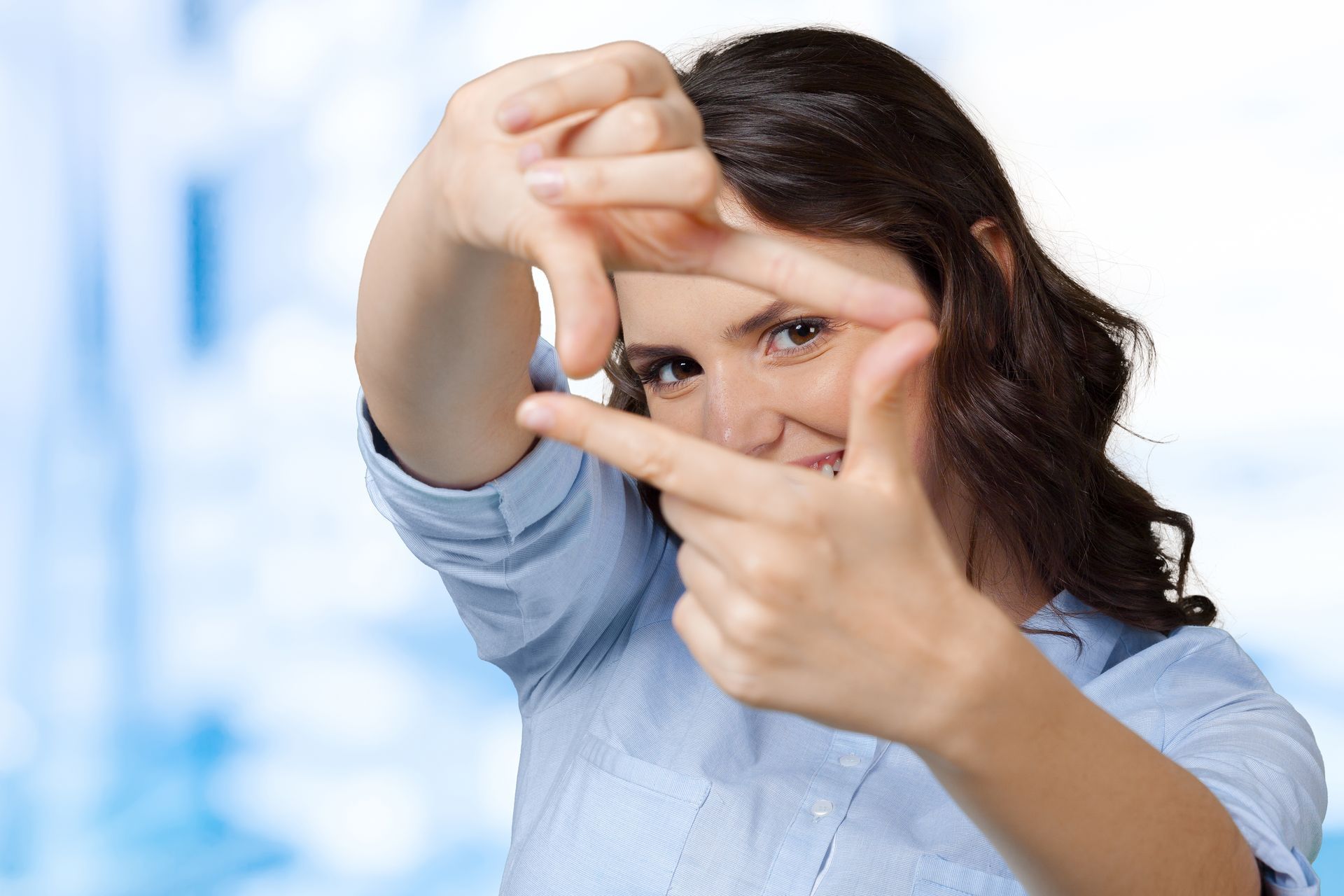 A woman is making a frame with her hands.