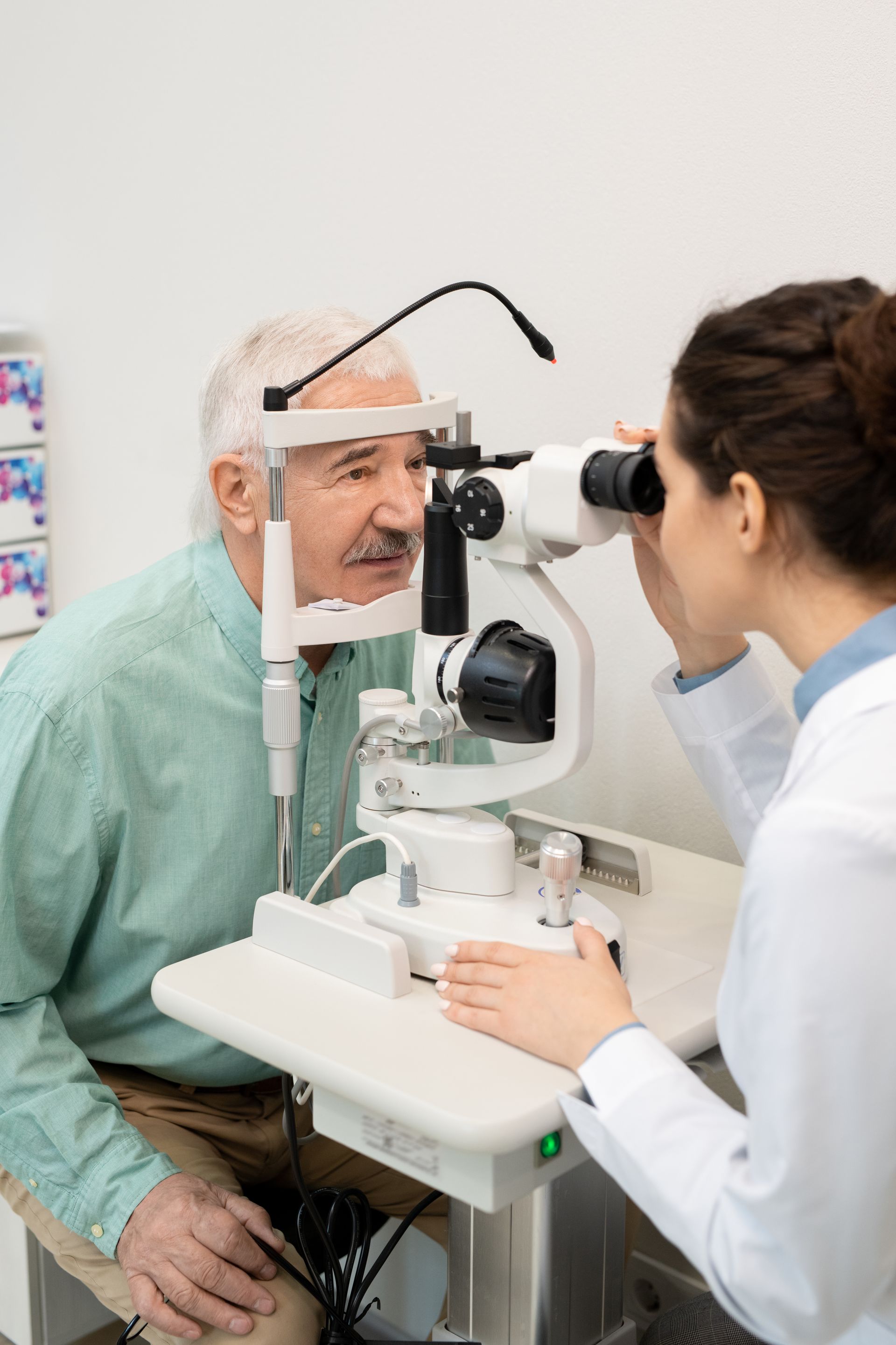 An older man is getting his eyes examined by an ophthalmologist.