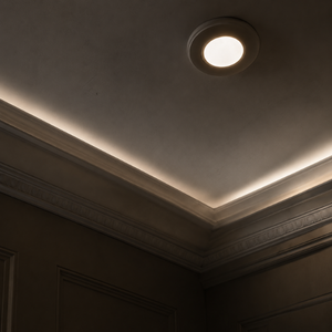 Ceiling corner with a recessed light and soft cove lighting in a dim room
