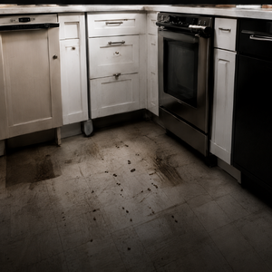 Dirty kitchen floor between white and black cabinets and a stainless-steel oven