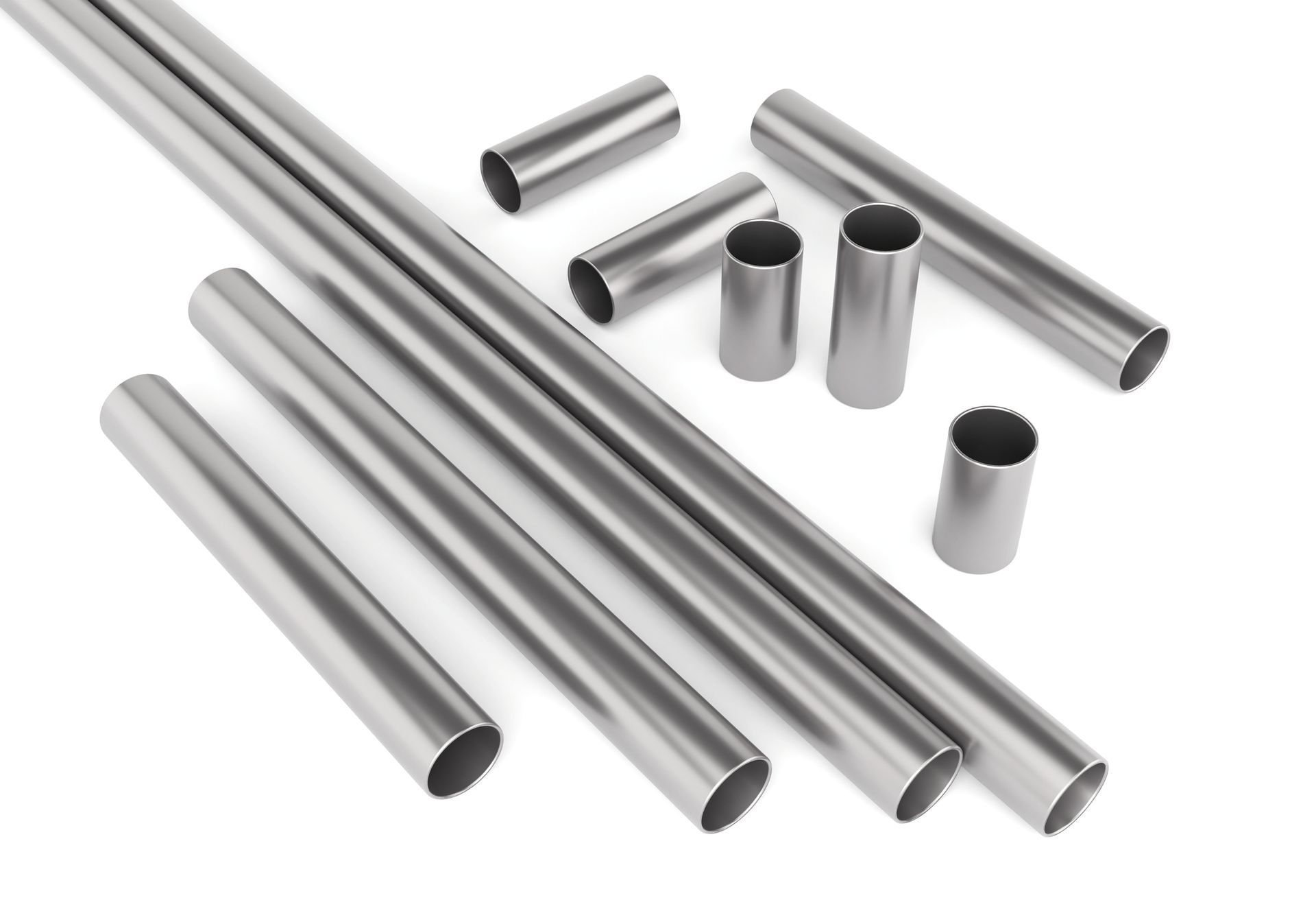 Silver metal tubes and cylinders of varying lengths, scattered on a white surface.