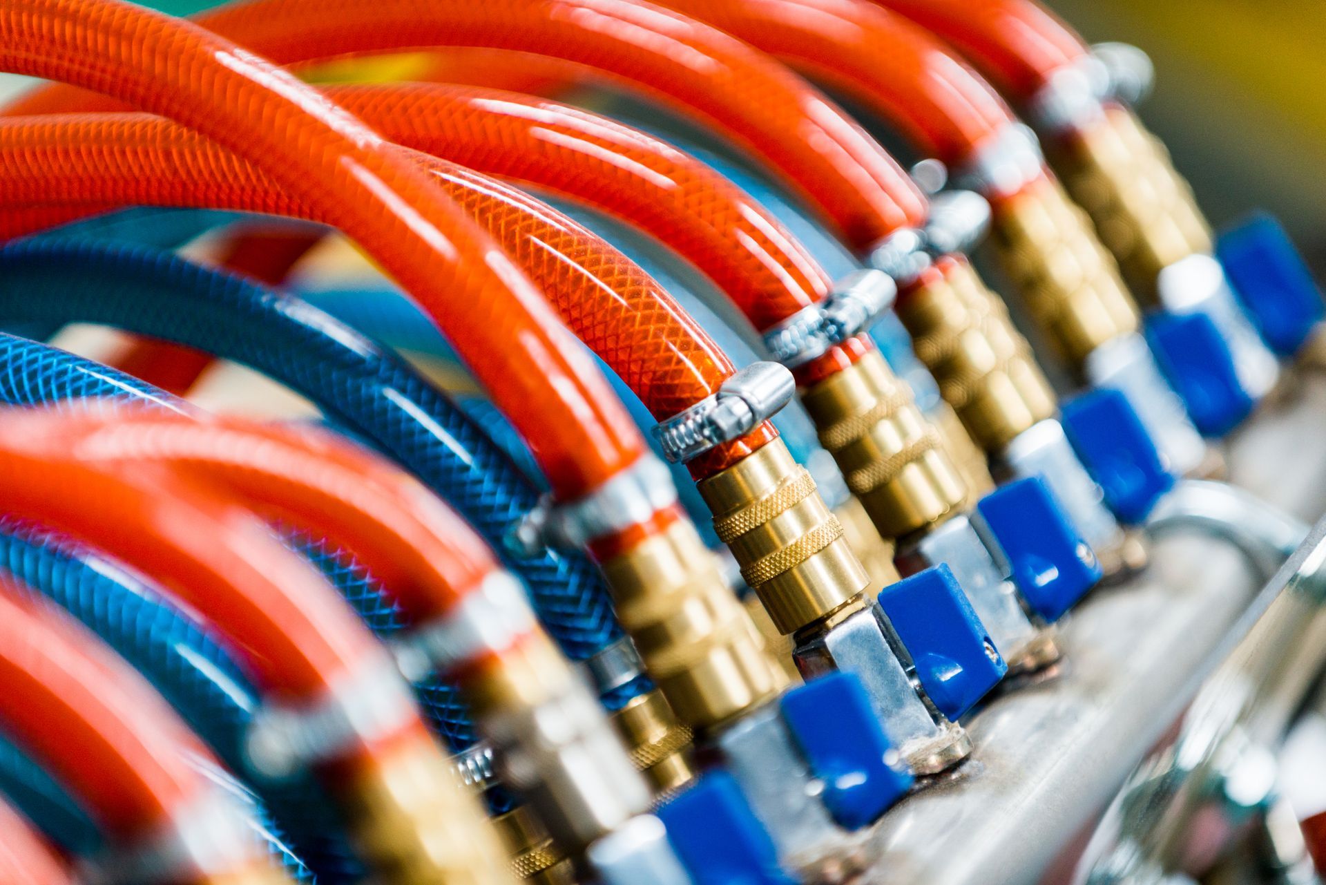 Red and blue hoses with brass fittings, tightly connected, in a mechanical setting.
