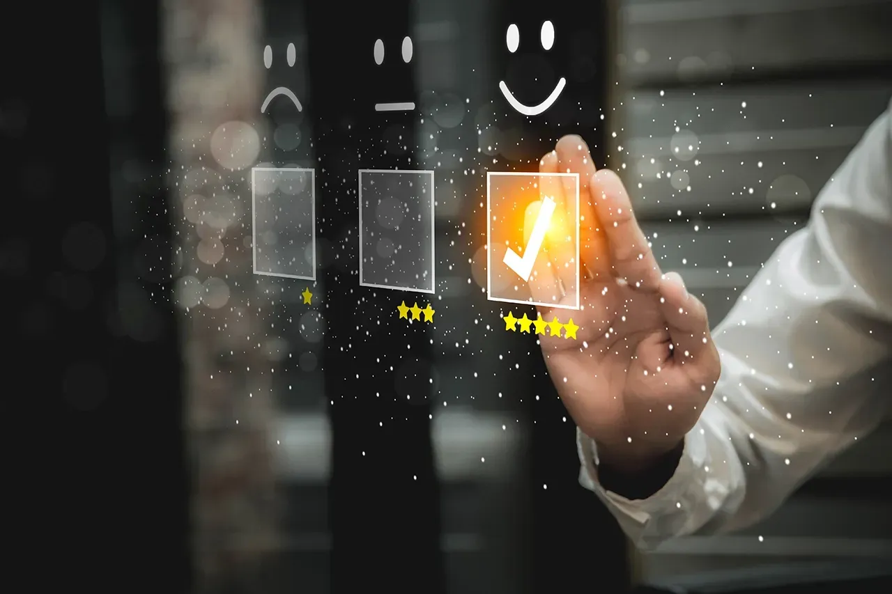 A hand selects a five-star rating with a checkmark on a digital interface featuring sad, neutral, and happy icons.