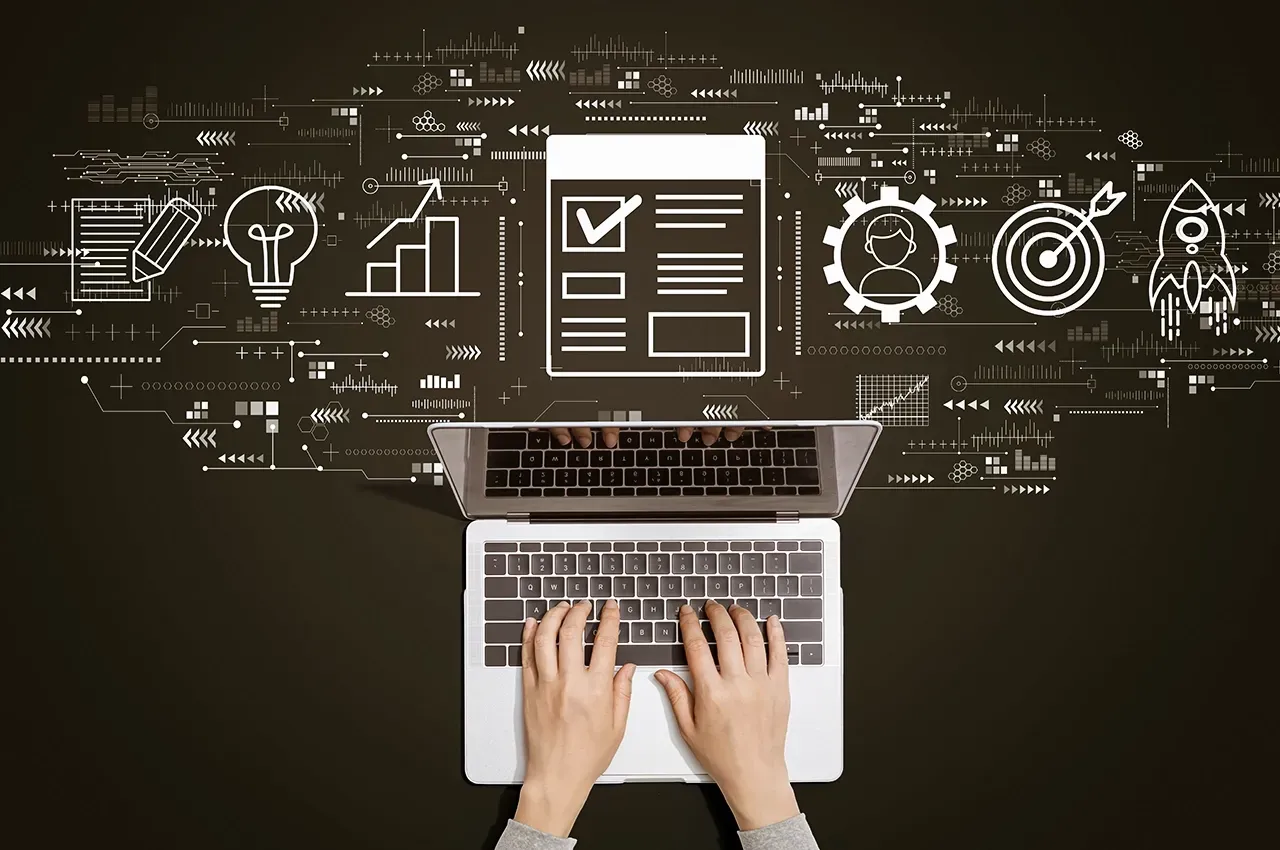 Top-down view of hands typing on a laptop, surrounded by icons representing project planning, innovation, and business.