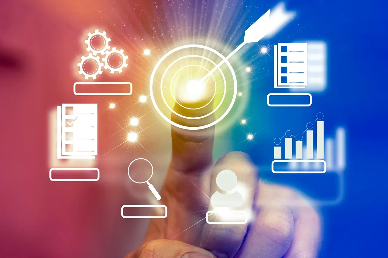 A hand reaches toward a glowing digital target icon, surrounded by business-related icons such as charts and checklists.