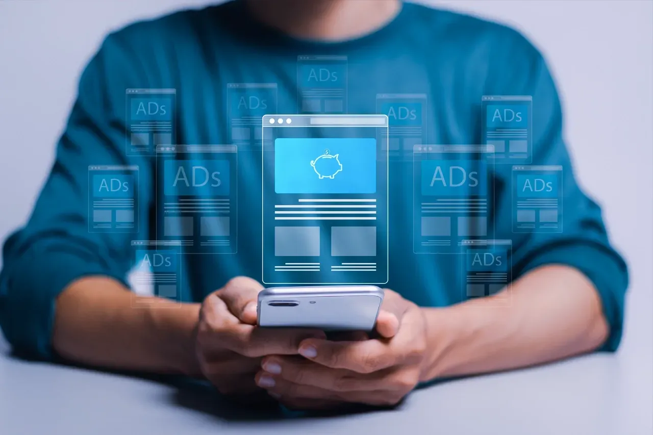 Hands holding a smartphone with a holographic interface displaying digital advertisements floating above the screen.