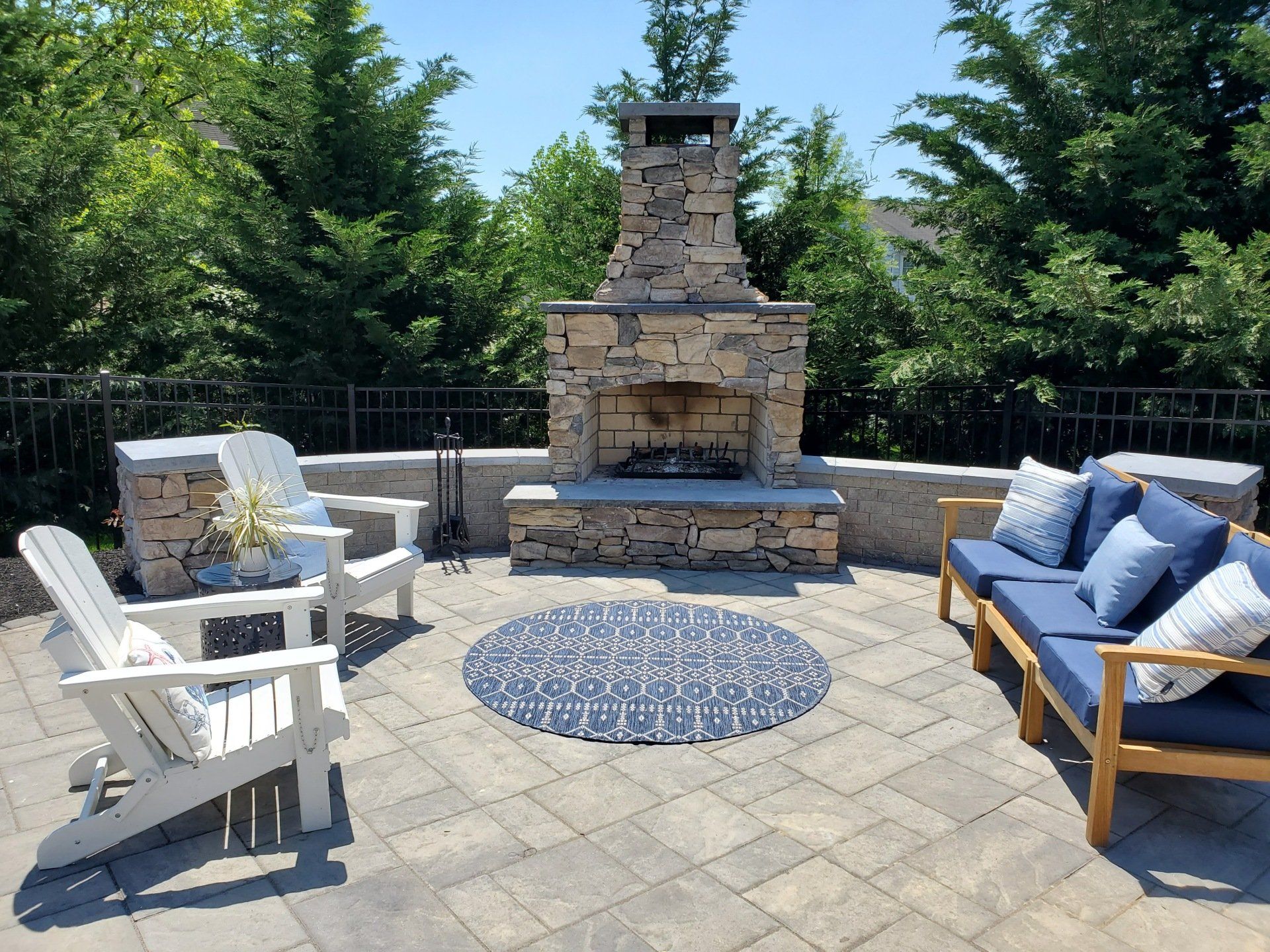 A patio with a fireplace and a couch and chairs