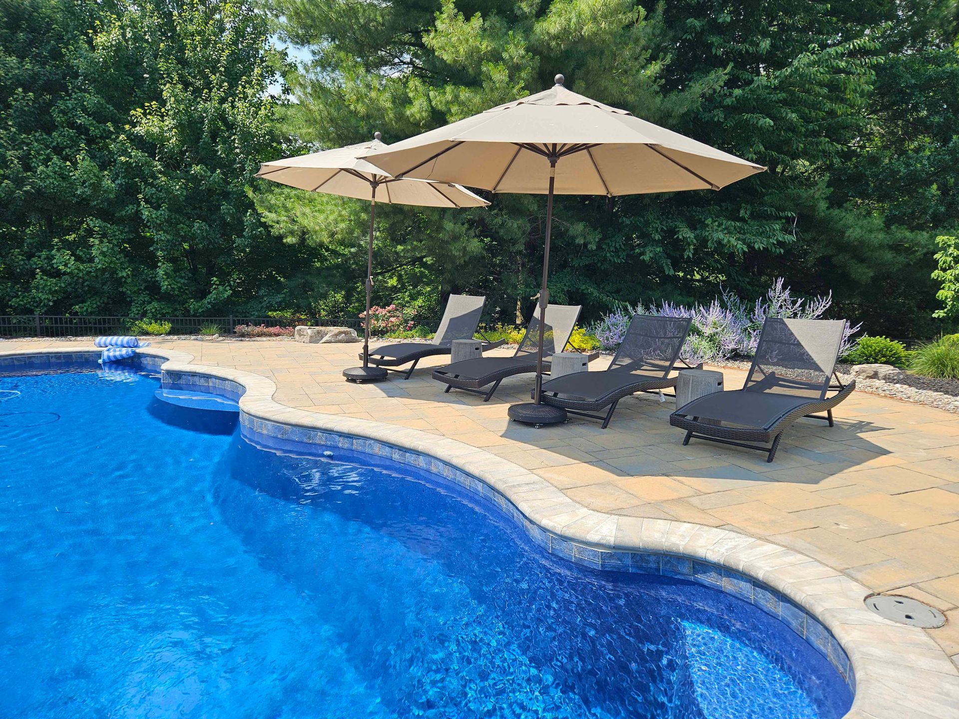 A Swimming Pool with Chairs and Umbrellas Around it