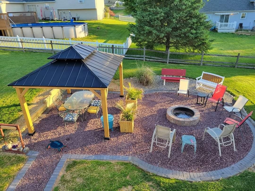 An aerial view of a backyard with a gazebo and a fire pit.