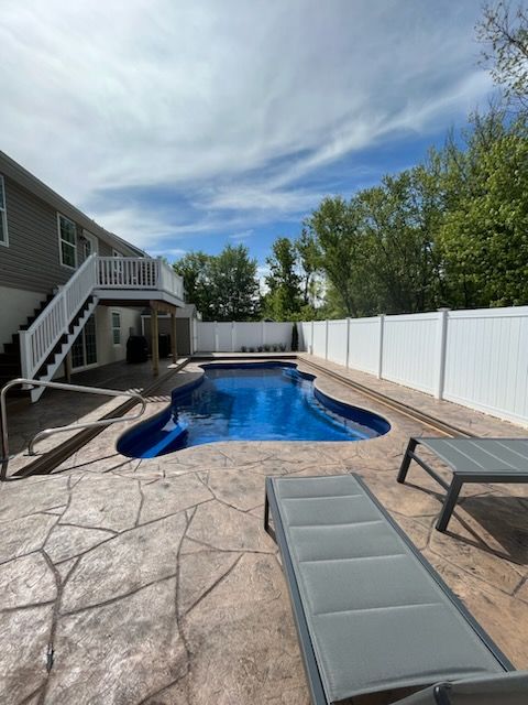 A large swimming pool with a white fence around it