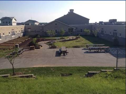 An aerial view of a picnic area in front of a building
