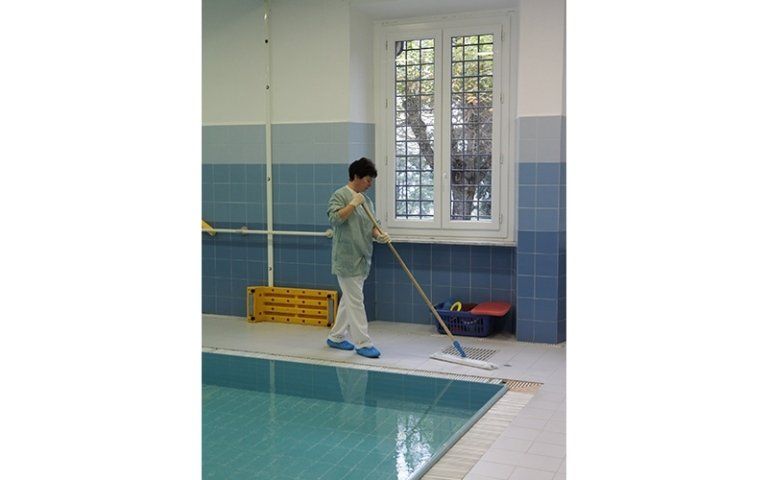 donna pulisce una piscina