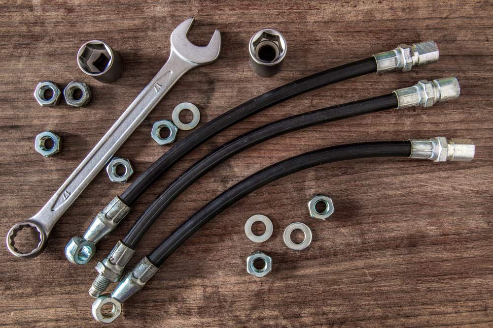 Wrenches, Nuts And Brake Hoses On Wooden Background — Bearfast Bearquip In Moree NSW