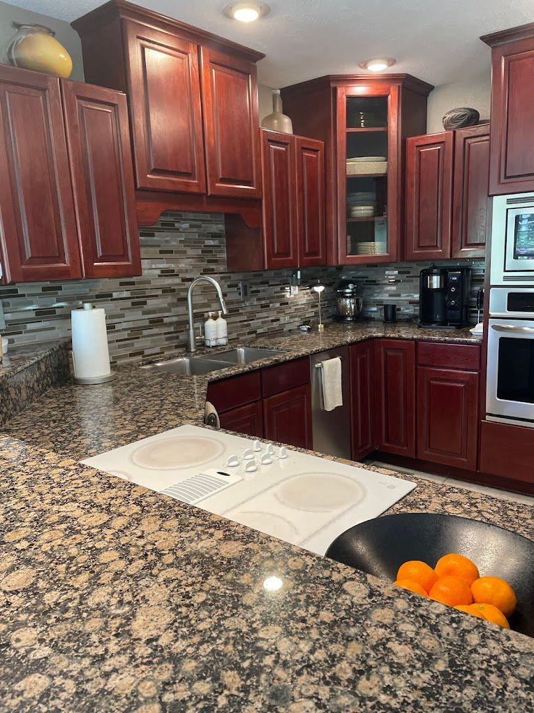 Kitchen with dark wood cabinets, granite countertops, and stainless steel appliances.