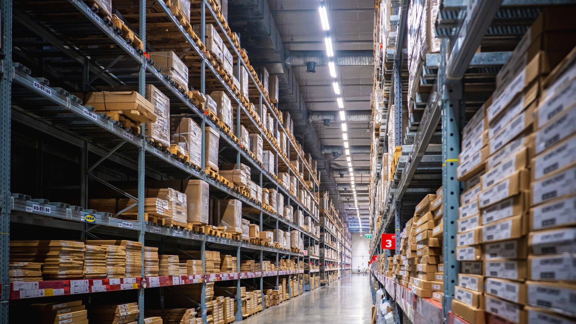 A large warehouse filled with lots of boxes on shelves