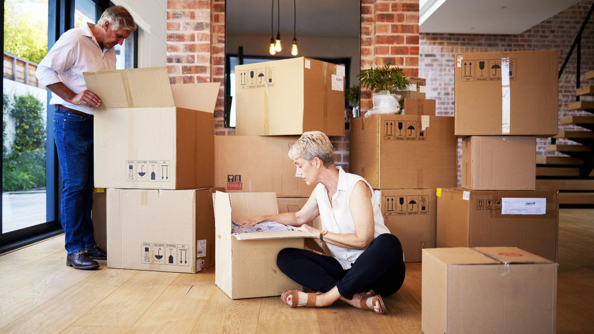 Married couple labelling boxes before a small move - Affordable movers