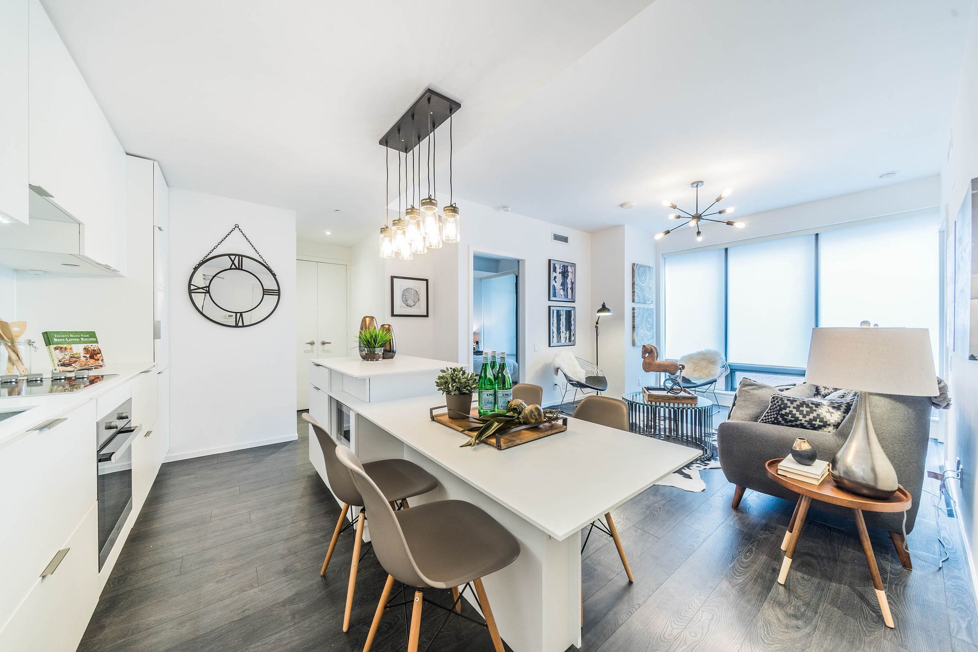 A living room with a table and chairs and a clock on the wall