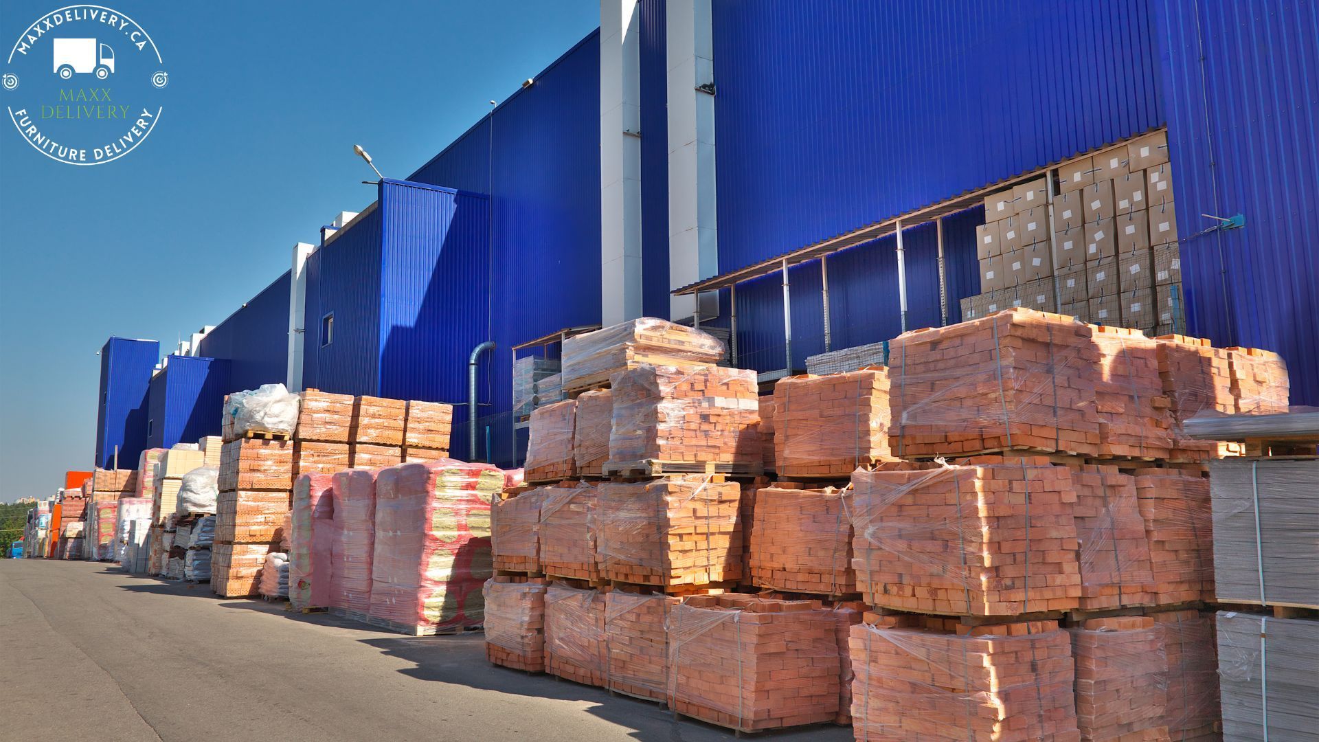 Bricks are stacked in front of a blue building