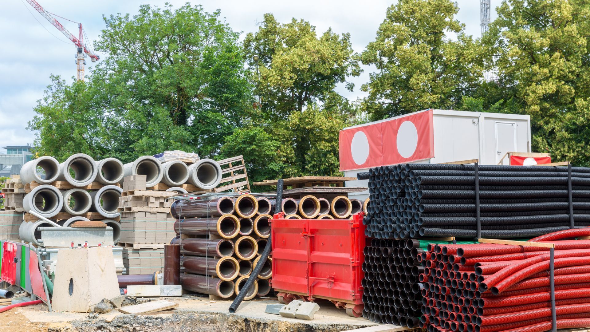 A construction site with a lot of pipes stacked on top of each other