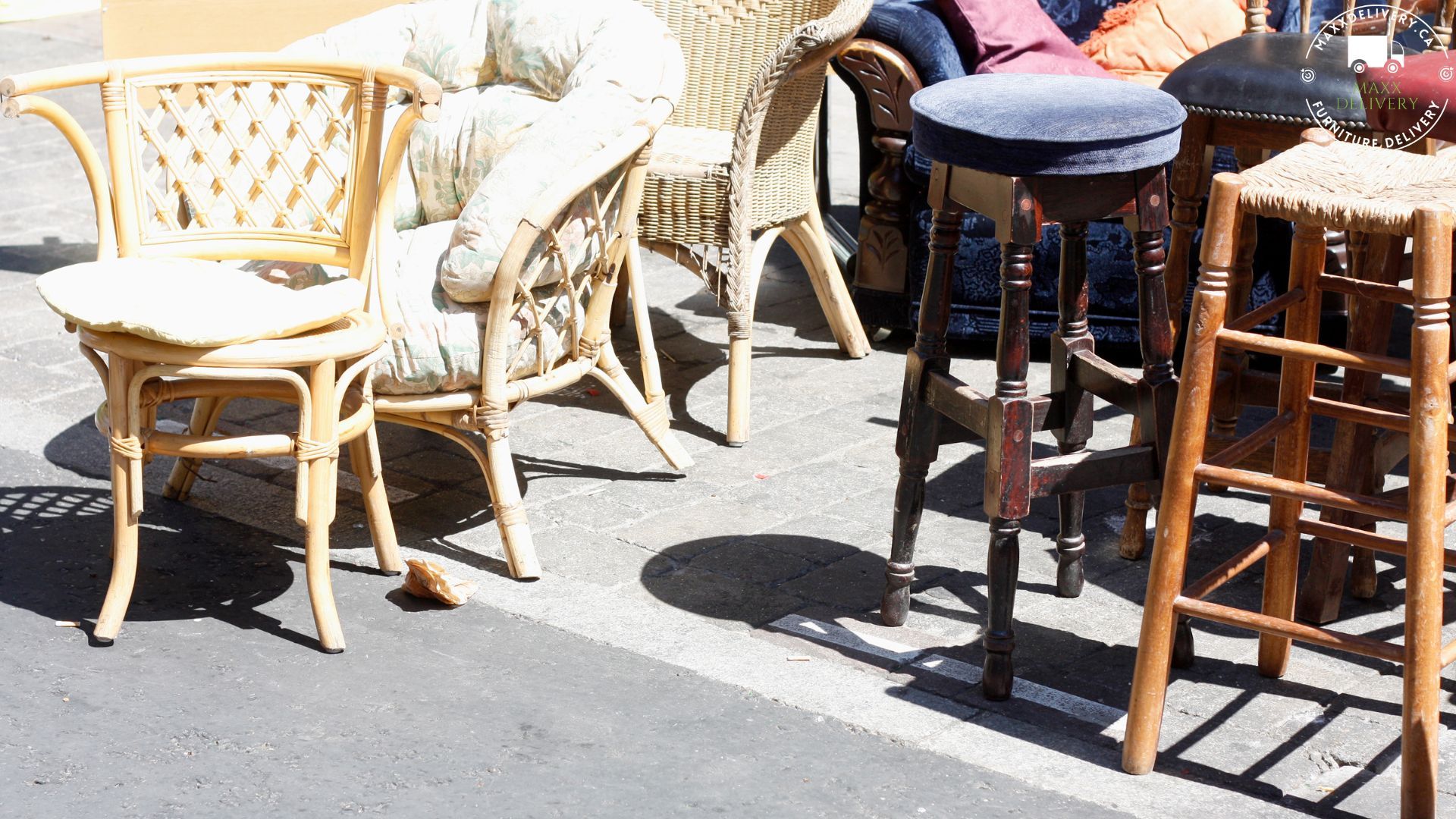 Wicker chairs and stools are lined up on the side of the road