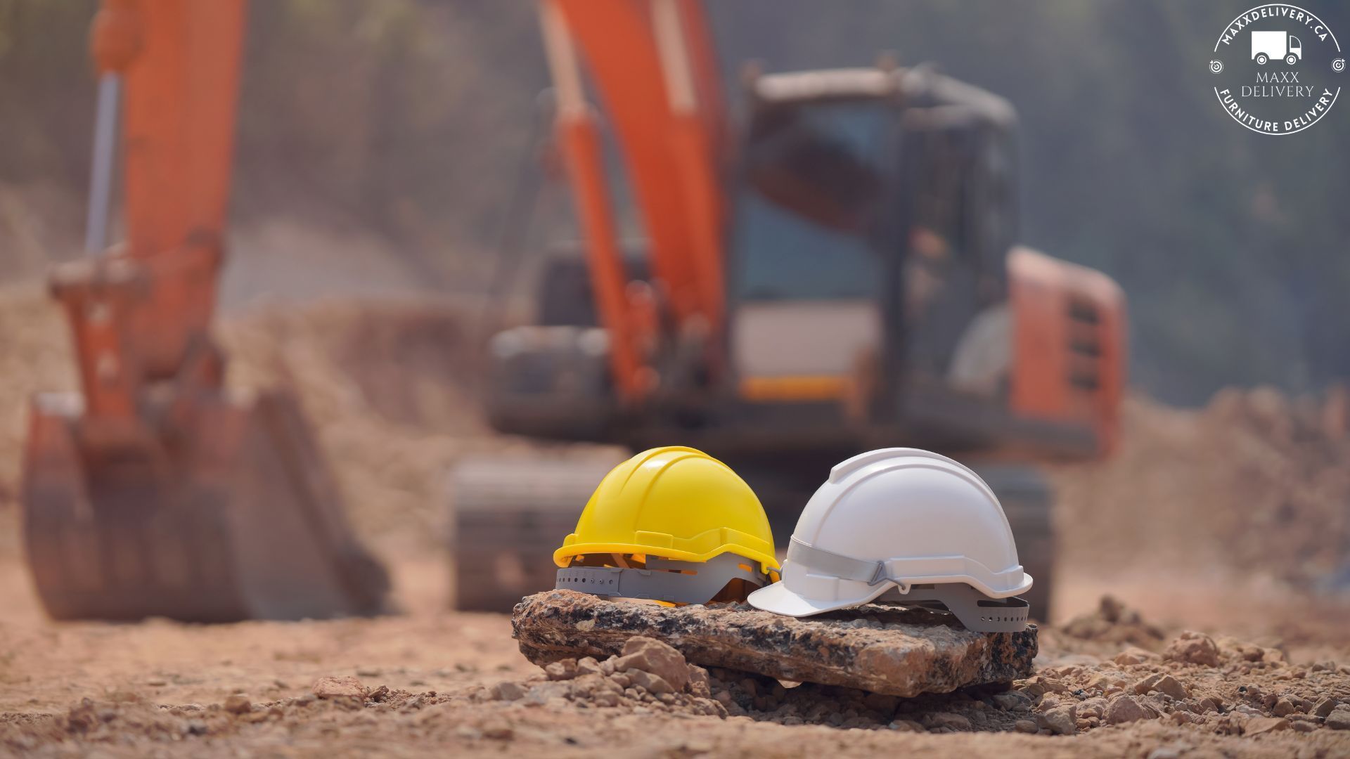 Two hard hats are sitting on a pile of dirt with an excavator in the background.