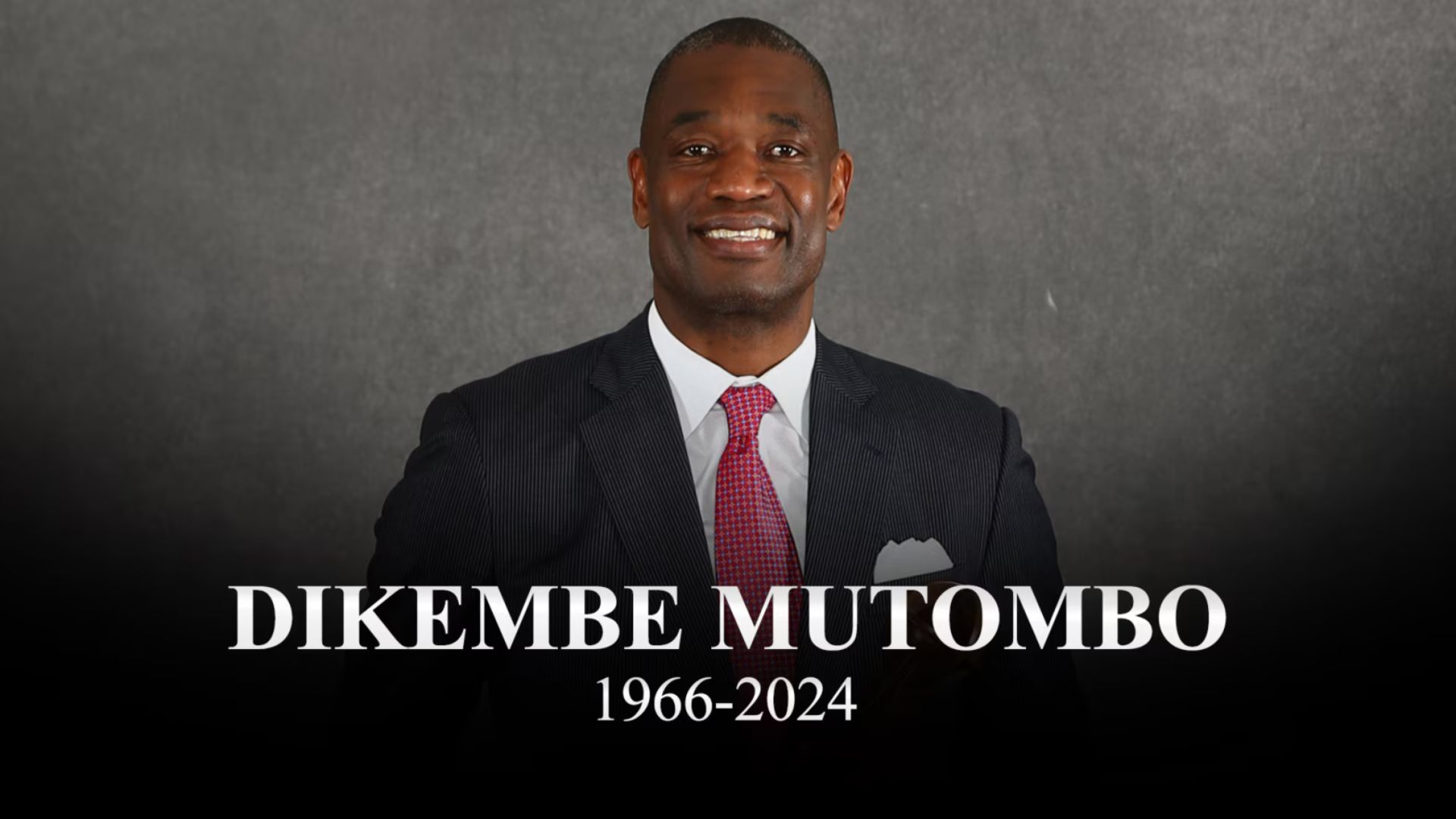 A man in a suit and tie with the name dikembe mutombo 1966-2024