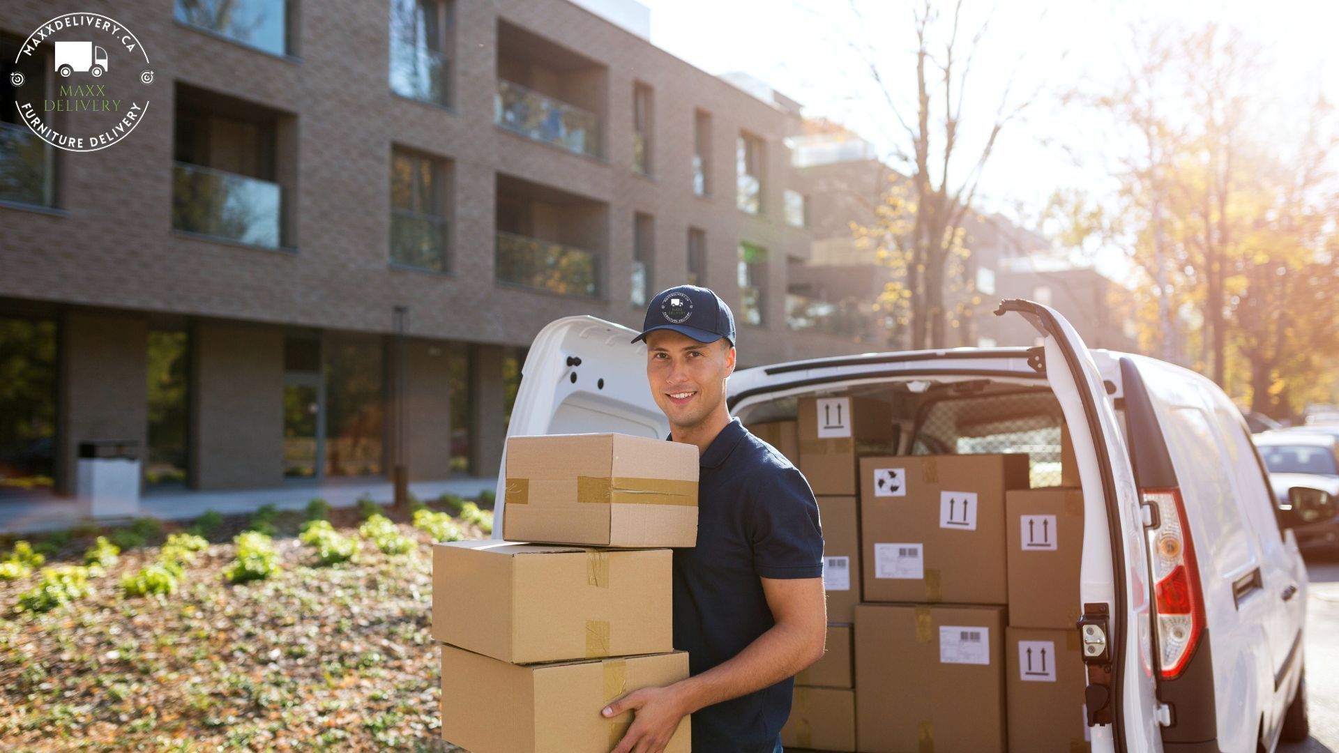 A delivery man is loading boxes into the back of a van