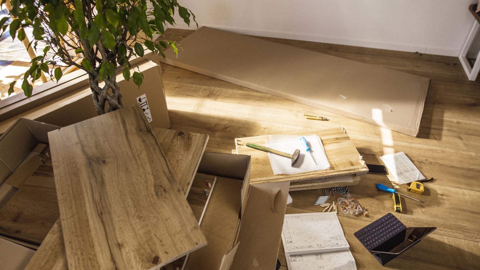 A pile of cardboard boxes on the floor with a tree in the background